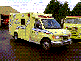 Yellow Demers ambulance parked outdoors with emergency lighting on the roof