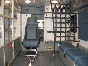 Interior of a Demers ambulance patient area with seating and mounted storage