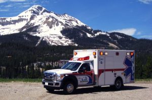 Demers ambulance parked outdoors with snow-capped mountains in the background