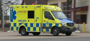 Yellow and blue checkered Demers ambulance driving down the street